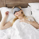 Woman sleeping with green earplugs and the Blockout Shade Mask in grey color.