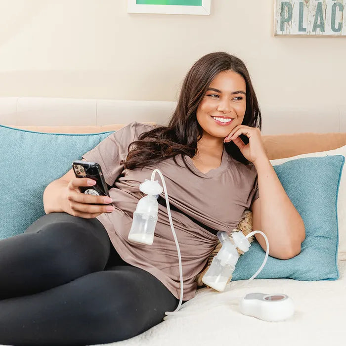 Woman laying down using breast pump.