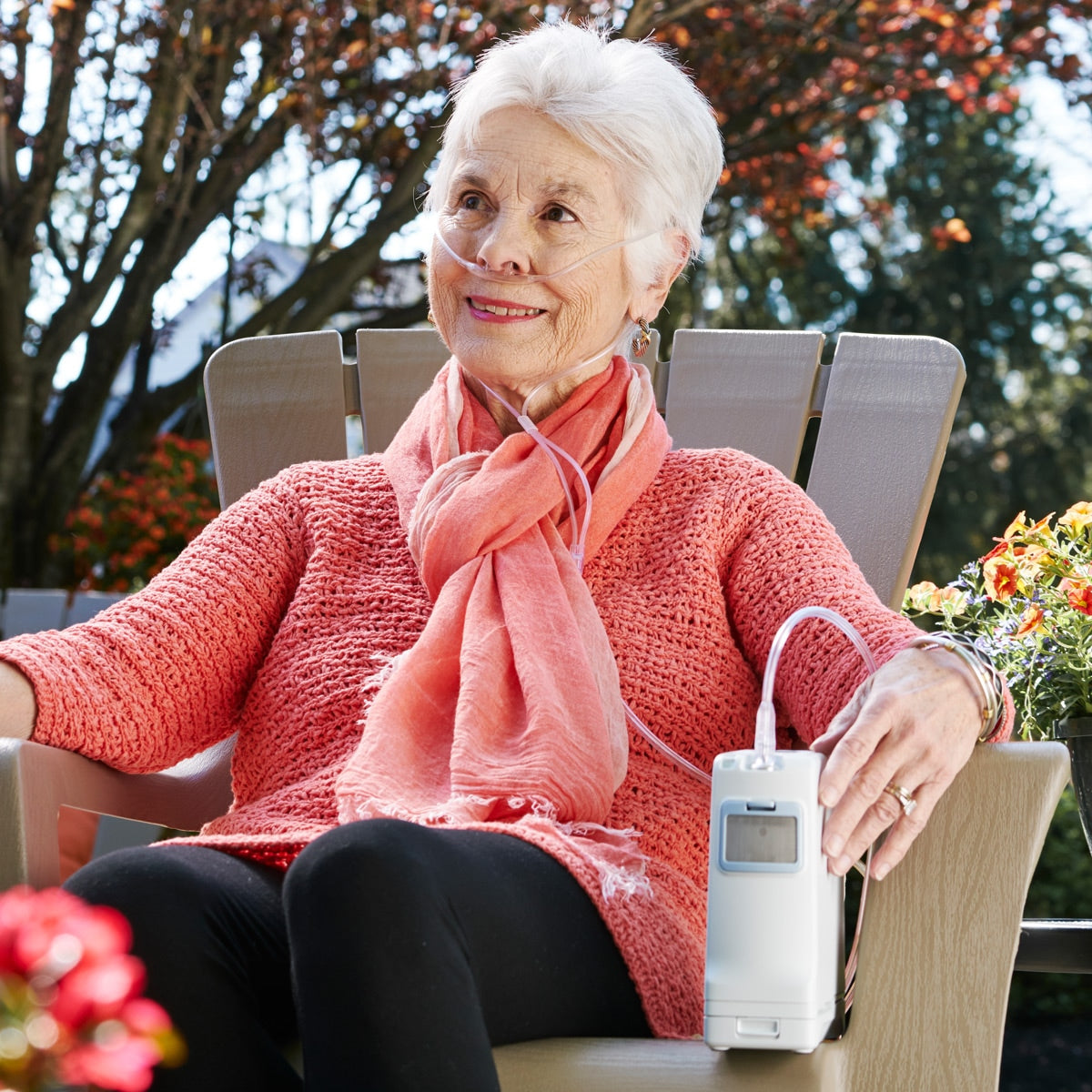 Woman Sitting With The Inogen One G4 Portable Oxygen Concentrator.