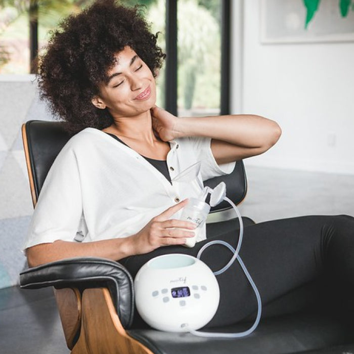 Woman relaxed using the breast pump.