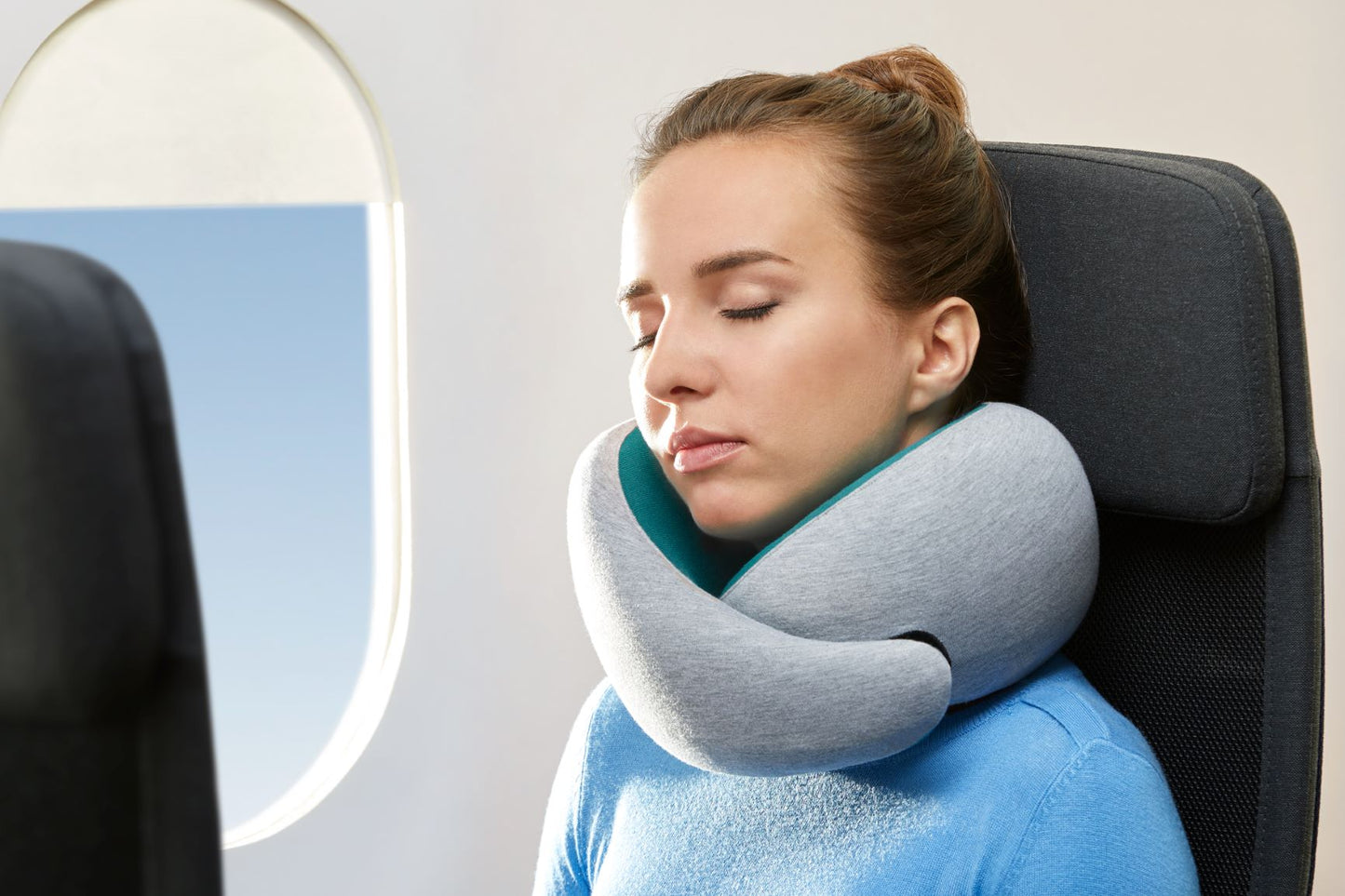 Woman Sleeping On Plane With Neck Pillow.