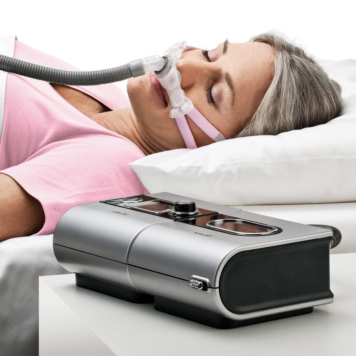 woman in bed wearing Swift FX Bella nasal pillow CPAP mask