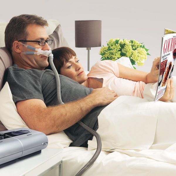 man wearing Swift FX Bella CPAP mask in bed with woman